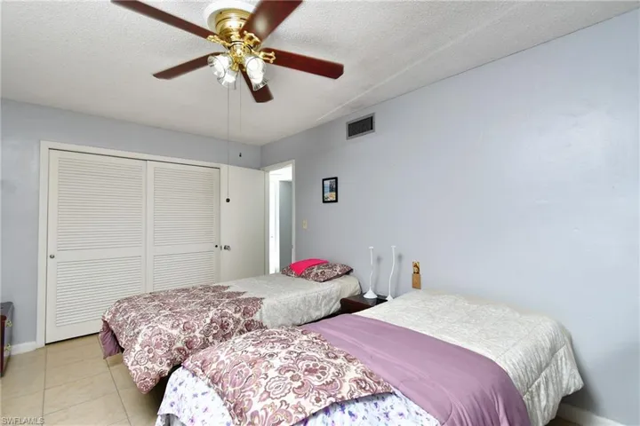 Interior space featuring light blue walls, a textured white ceiling, and light-toned tile flooring
