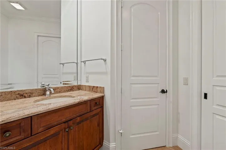 Guest 1/2 Bathroom  located near Primary Bedroom with crown molding and vanity