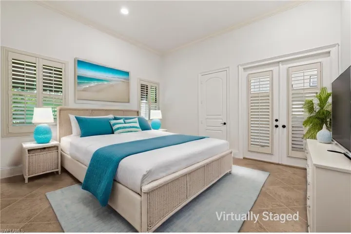 Guest Bedroom #4 with French Doors to Screened Pool/waterfall, plantation Shutters, & crown Molding