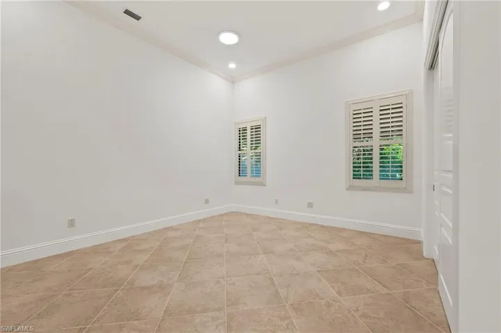 Guest bedroom #3 featuring large closet, Planation Shutters, & corwn molding