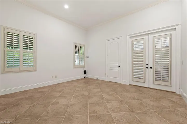 Guest Bedroom #4 with French Doors to Screened Pool/waterfall, plantation Shutters, & crown Molding