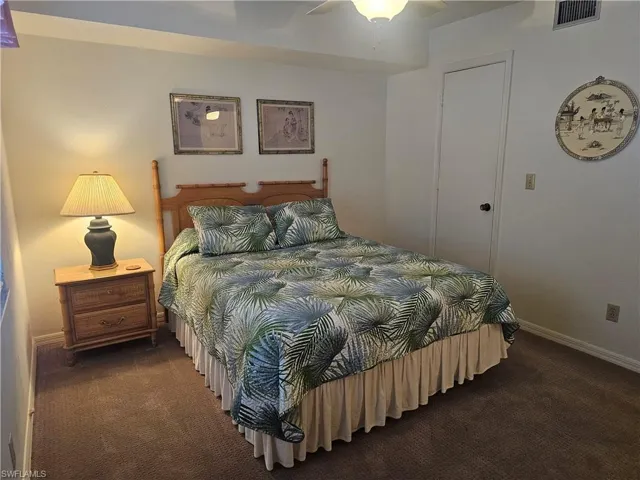 Bedroom with dark colored carpet and ceiling fan