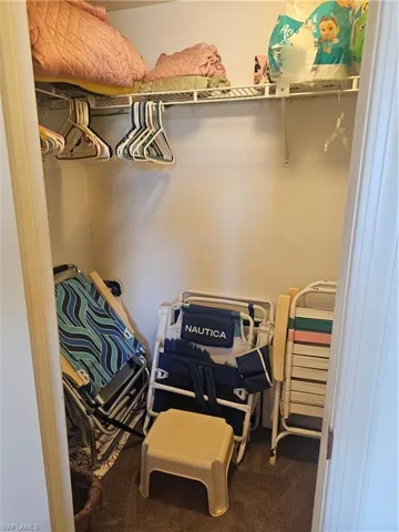 Walk in closet with dark colored carpet