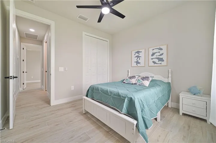 Bedroom featuring ceiling fan, a closet, and light hardwood / wood-style flooring