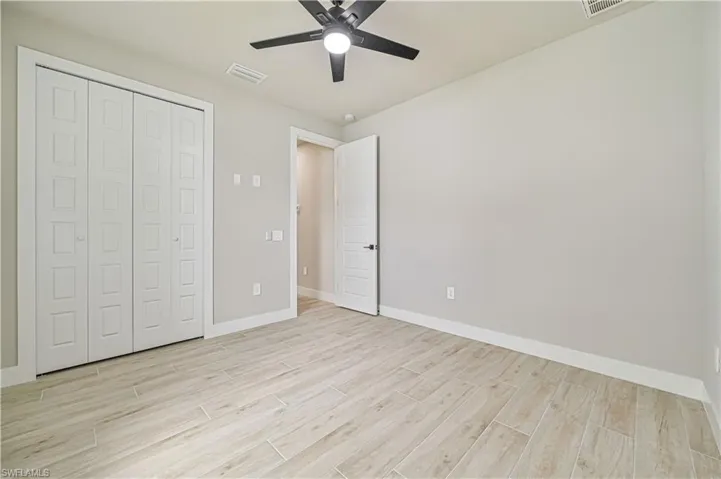 Unfurnished bedroom with ceiling fan, light hardwood / wood-style flooring, and a closet