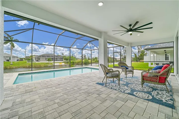 View of pool featuring a patio area, a lanai, an outdoor living space, and ceiling fan