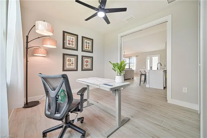 Office area featuring sink, light wood-type flooring, and ceiling fan