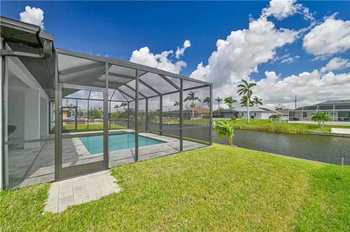 View of pool featuring a water view, a patio, a yard, and a lanai