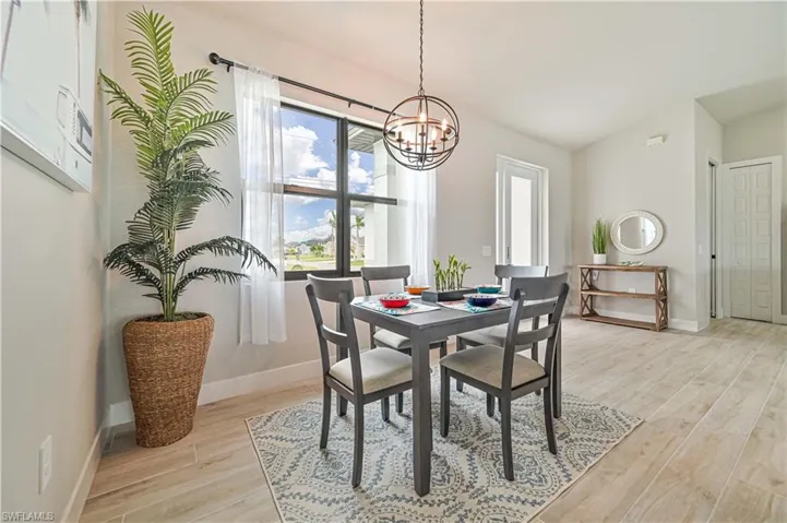 Dining room with vaulted ceiling, a chandelier, and light hardwood / wood-style floors