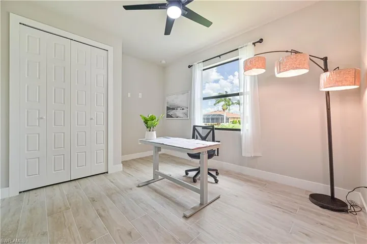 Office space with light hardwood / wood-style flooring and ceiling fan