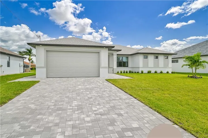 View of front of property featuring a front lawn and a garage