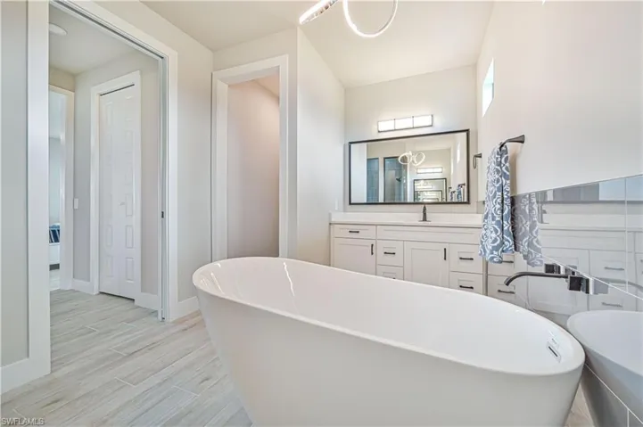 Bathroom with wood-type flooring, vanity, and a bathtub