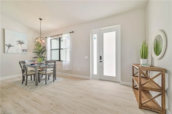 Dining space featuring lofted ceiling, an inviting chandelier, and light hardwood / wood-style floors