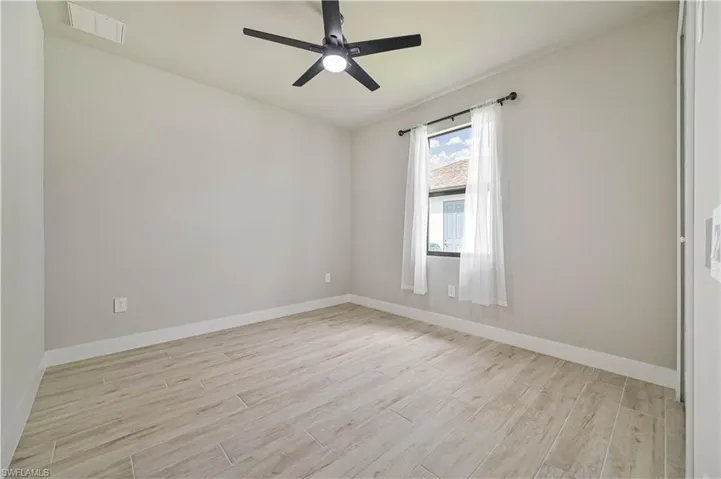 Unfurnished room featuring light wood-type flooring and ceiling fan