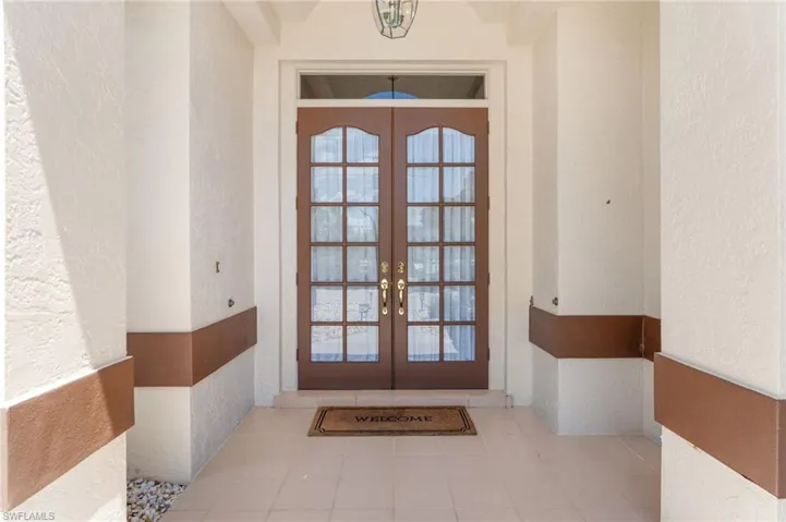 Full bathroom with a stall shower, vanity, wallpapered walls, and light tile patterned flooring