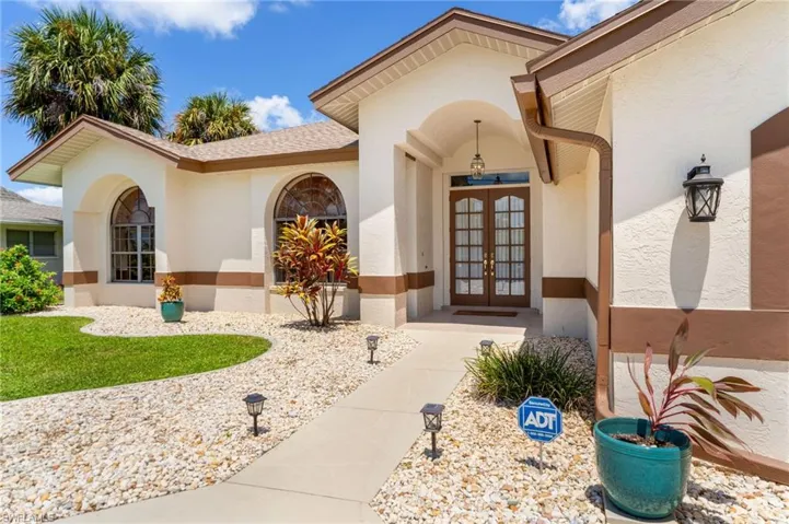 Doorway to property featuring french doors and stucco siding