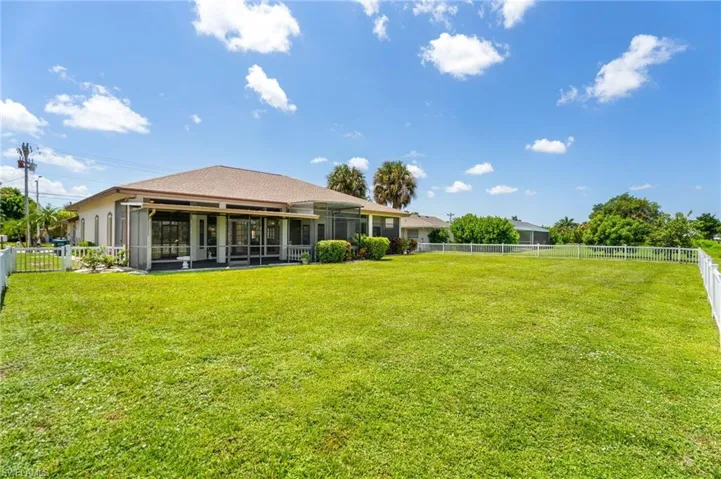View of front of home with stucco siding, curved driveway, an attached garage, a front lawn, and a shingled roof
