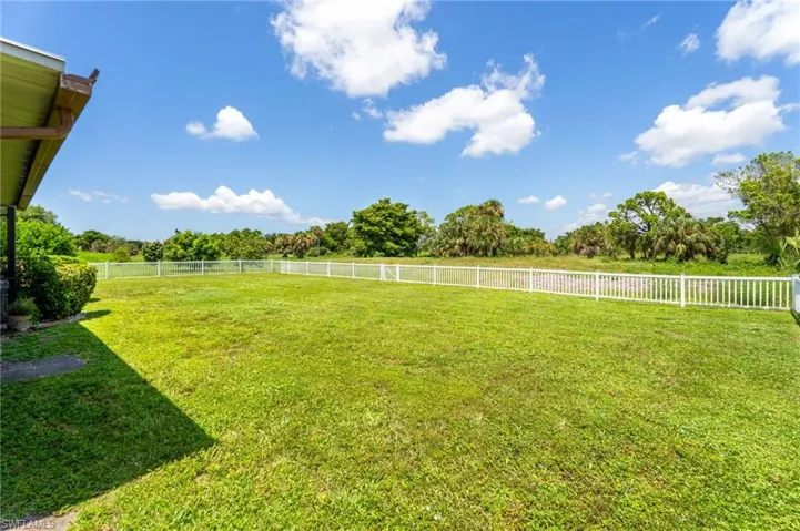 Fenced backyard featuring landscaped and treed view
