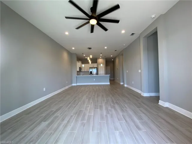 Unfurnished living room featuring recessed lighting, baseboards, light wood-style floors, and a ceiling fan