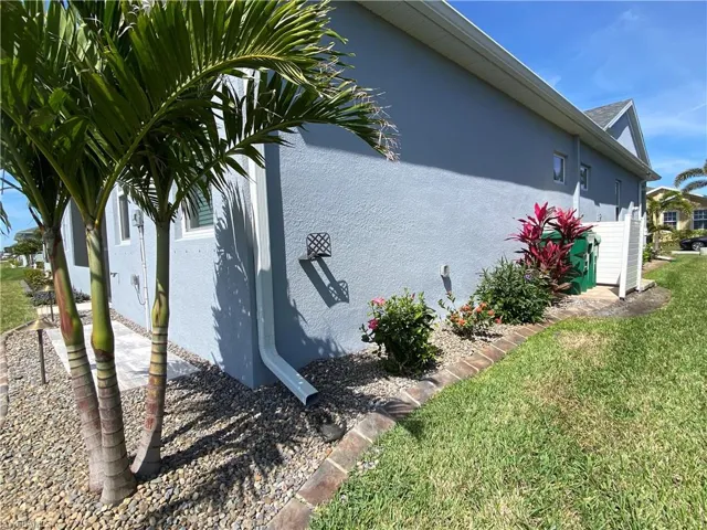 View of side of property featuring stucco siding and a lawn
