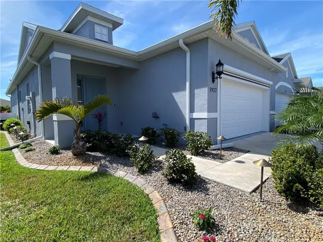 View of side of property featuring concrete driveway, a garage, and stucco siding
