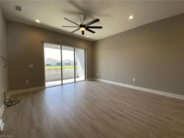 Empty room featuring visible vents, baseboards, a ceiling fan, and wood finished floors