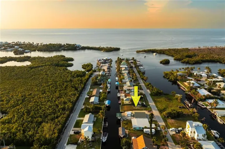 Aerial view of property and surrounding area with a nearby body of water and nearby suburban area
