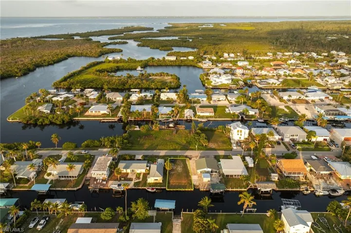 Aerial view of property and surrounding area featuring a large body of water and nearby suburban area