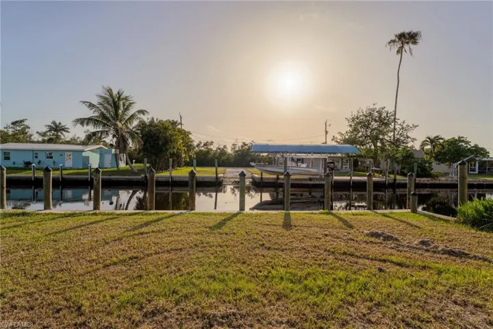 Dock with a water view, a lawn, and boat lift