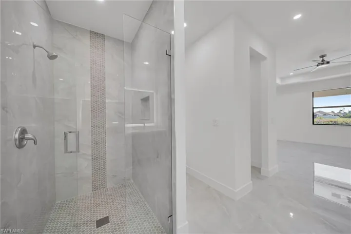 Full bathroom with a marble finish shower, recessed lighting, and a ceiling fan