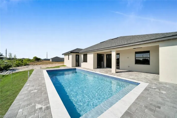 Outdoor pool with a patio and a yard