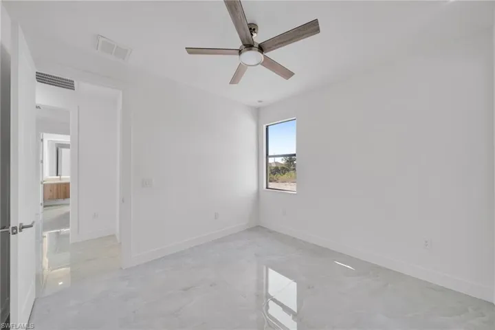 Spare room with ceiling fan and concrete flooring