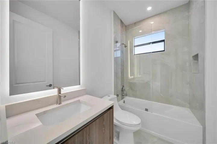 Bathroom with vanity, shower / bathtub combination, and recessed lighting