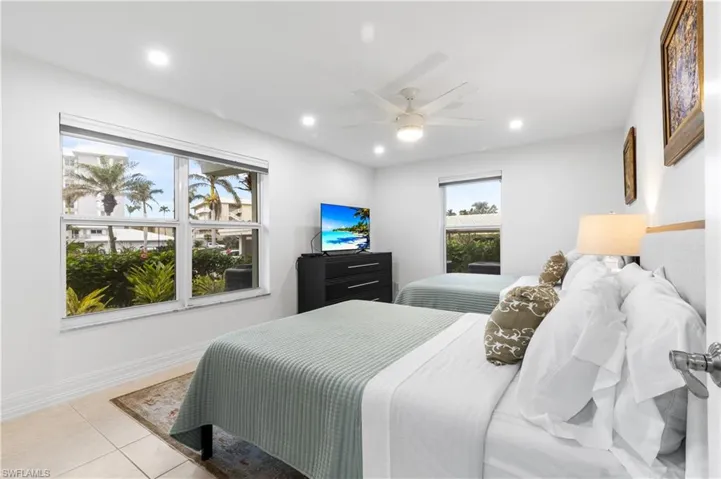 Spacious bedrrom shows 2 double beds with night stand between.  Bedroom has walk-in closet.