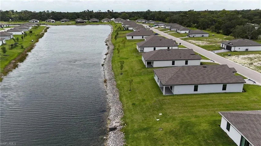 Waterfront properties with contemporary single-story architecture, dark shingle roofs, and light-colored exteriors