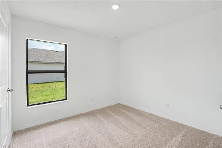 Neutral tone carpet flooring, white painted walls, and a recessed ceiling light fixture
