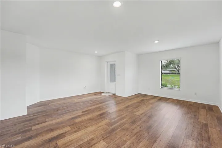 Open concept interior featuring wide plank wood-finish flooring, recessed lighting, and a neutral color palette