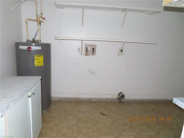 Laundry area featuring water heater, light flooring, and washer hookup