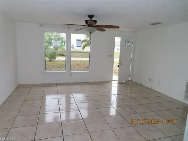 Empty room featuring a ceiling fan and light tile patterned floors