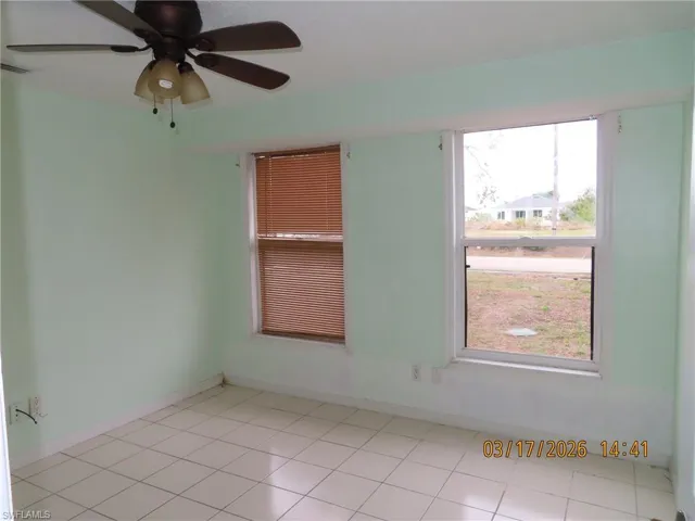 Empty room featuring ceiling fan and light tile patterned flooring