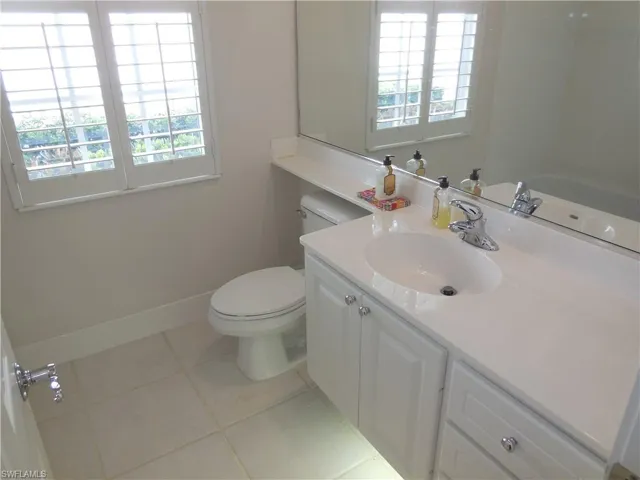 Bathroom featuring toilet, tile patterned floors, vanity, and plenty of natural light