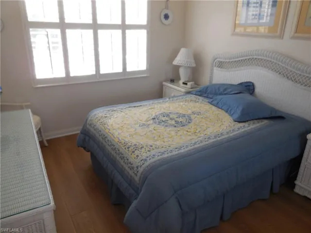 Bedroom featuring wood finished floors, baseboards, and multiple windows