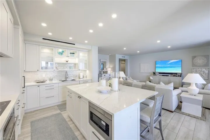 Kitchen with a center island, open floor plan, appliances with stainless steel finishes, a kitchen breakfast bar, and backsplash