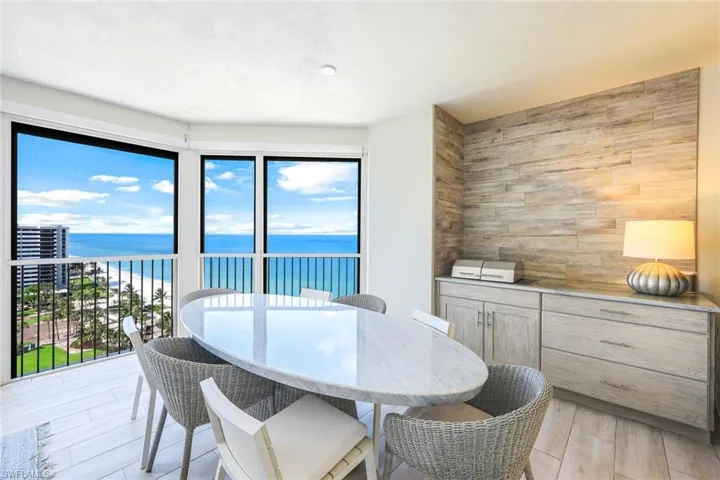 Dining room featuring a water view, wood walls, and light wood finished floors