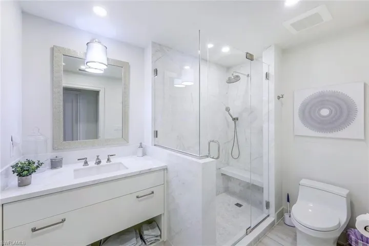 Full bathroom featuring vanity, a shower stall, and recessed lighting