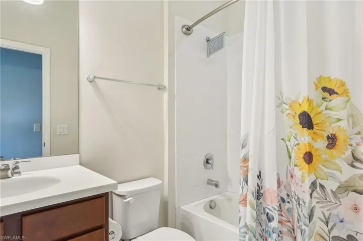 Full bathroom featuring shower / bath combo with shower curtain, toilet, and vanity