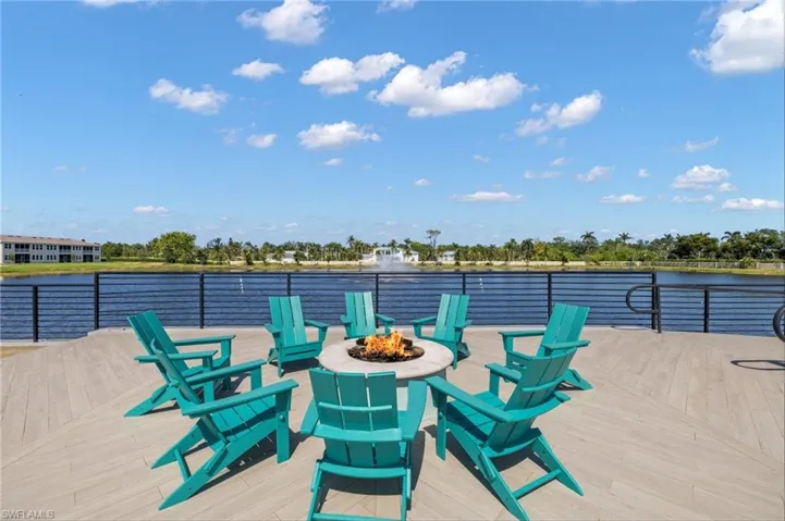 Wooden deck featuring an outdoor fire pit and a water view