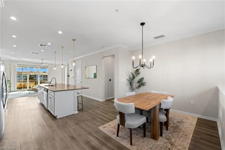 Dining area featuring recessed lighting, dark wood finished floors, crown molding, and a chandelier