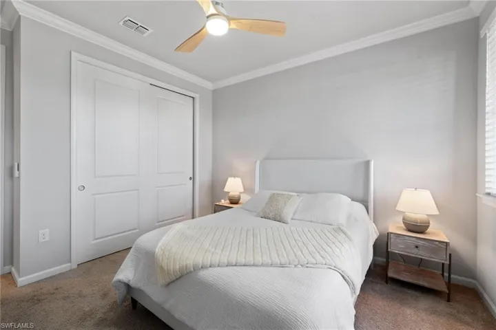 Bedroom featuring ornamental molding, carpet flooring, a closet, and a ceiling fan