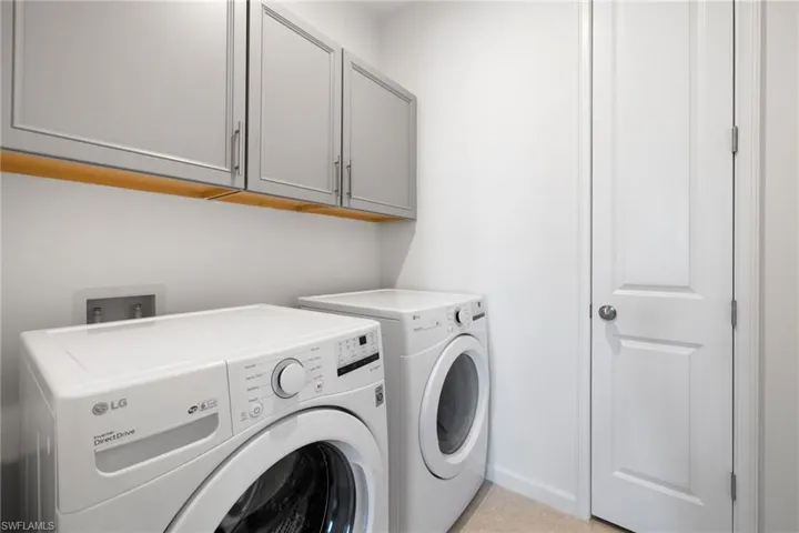 Washroom featuring washer and dryer and cabinet space